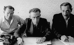 Close-up portrait of three administrators in an office at an unidentified displaced persons camp in Germany.