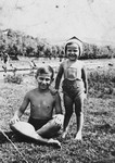 A brother and sister pose in their bathing suits by a river near Lvov.