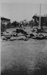 American soldiers walk past the bodies of prisoners shot by the SS during the evacuation of the Ohrdruf concentration camp.