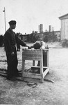A survivor demonstrates methods of torture used by guards at the Ohrdruf concentration camp to American soldiers