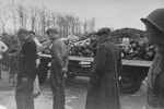 German civilians, who have been forced to tour the newly liberated Buchenwald concentration camp, view a flatbed truck piled with corpses.
