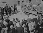 German civilians under U.S. military escort are forced to view a wagon piled with corpses in the newly liberated Buchenwald concentration camp.