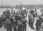 Survivors congregate in the central compound of Buchenwald along with American soldiers and journalists during an official tour of the liberated camp by an international group of radio commentators.