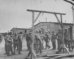 American soldiers view a gallows erected between rows of barracks in the Ohrdruf concentration camp.