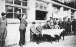 Jewish DPs in the Mittenwald displaced persons camp conduct a meeting at which they protest British immigration policy to Palestine while they commemorate the death march from Dachau to Tyrol.