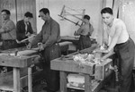 Jewish men measure and plane wood in the carpentry workshop of an ORT (Organization for Rehabilitation through Training) training program in the Landsberg displaced persons' camp: [Oversized print]