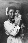 Tonia Rotkoff, a nurse at the UNRRA house in the Landsberg DP camp, holds a young baby.