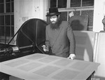 Rabbi Samuel Jakob Rose, rabbi of the American zone of occupation in Germany, and a survivor of Dachau, examines the galleys of the first postwar edition of the Talmud to be printed in Germany.