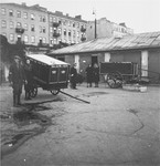 Funeral wagons, cemetery staff, and other people on the grounds of the Jewish cemetery on Okopowa Street in the Warsaw ghetto.