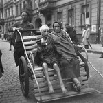 A woman and her ill child on a rickshaw in the Warsaw ghetto.