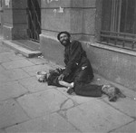 A destitute beggar on the street in the Warsaw ghetto.
