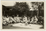 Children in a Mannheim preschool sit outside on the lawm.