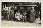 The Kalberman family poses next to an automobile.