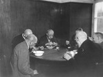 A group of elderly survivors eat a hearty meal at the Hadamar Institute after war crimes investigators demanded they be given larger rations.