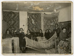 A group of Beit Yaakov women sew lace curtains in Rymanow, Poland.