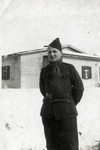 Mendel Einhorn stands outside a barrack in the snow in a prisoner of war camp in Germany.