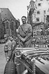 Standing in his car, Adolf Hitler waits to review the next column of passing SA troops during a Reichsparteitag (Reich Party Day) parade.