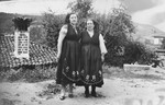 Gisela Tchitchekik (left) and a village woman pose together in matching traditional costumes in the village where Gisela and her sons are spending their summer vacation.