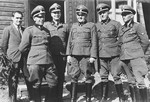 Group portrait of SS officers in front of a barrack in the Hinzert concentration camp.