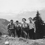 Two Jewish refugee youth pose with the Dym family in the hills outside of Zurich.