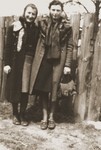 Two young women pose in front of a fence in the Zelow ghetto.