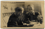 Two young men work at a desk [in the Lodz ghetto].
