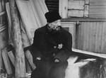 The preacher, Rabbi Most, sits outside his dwelling in the Kovno ghetto, where he awaits deportation.