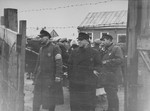 Three Jewish ghetto officials stand at one of the gates to the Kovno ghetto.