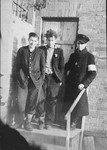 Two prisoners and a Jewish policeman standing in front of the ghetto jail.