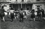 Zionist youth belonging to the Kvutza Borochov dance a horah on the lawn of their hachshara outside of Paris.