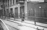 Lodz ghetto Jews behind the wooden and barbed wire fence that separated the Lodz ghetto from the rest of the city (probably taken from Zgierska Street).