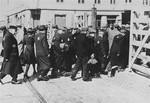 Jewish men and women entering the Lodz ghetto.