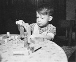 Joel Fabian, a young Jewish boy living in wartime Berlin, plays with blocks at a table.