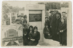 An extended Polish Jewish family gathers by a tombstone in the Jewish cemetery in Lodz.