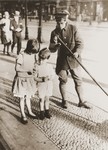 Two young children exchange cigarette coupons on the street in Berlin.