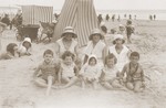The Rubinsztejn family poses in front of a cabana on a beach in France.