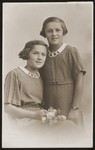 Studio portrait of Hana and Marie Spaeth wearing dresses with collars incorporating the Olympic rings.