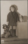 Studio portrait of Ruth Wottitzky with a doll and stuffed animal.