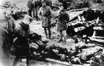 Soviet troops view the bodies of prisoners from the Klooga concentration camp that have been stacked on a pyre.