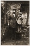 Hirsch Glicenstein poses with his young nephew, Leo Grinberg, in front of a brick house in Kalisz.