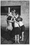 Alex Hochhauser hugs a group of children in front of the Maccabi sports gymnasium in Zilina, Czechoslovakia.