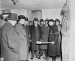 A survivor demonstrates SS methods of torture and execution in Buchenwald to a visiting delegation of American congressmen.
