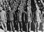 Dutch Jews wearing prison uniforms marked with a yellow star and the letter "N", for Netherlands, stand at attention during a roll call at the Buchenwald concentration camp.