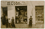A group of men pose in front of the store belonging to Martin Cohn (grandfather of the donor).