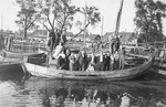 Eliezer Kaplan poses with friends from the Zionist movement in a fishing boat anchored at a small boating dock in a Lithuanian village.