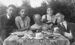 A group of young teachers from the Jewish Volksschule (elementary school) no.3 in Utena, socialize over tea taken outside in front of the school.