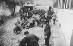 Jews are forced to clean blood from the cobblestone pavement of the Iasi police headquarters courtyard during the pogrom.