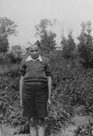 A young boy who is a member of the Eshel (Irgun Le-Shmirat Ha-Ganim) garden guards, poses outside in the Kovno ghetto.