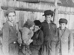 A group of young boys holding a small child in the Kovno ghetto.