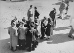 Jews converse outside in the "Sammelstelle" [gathering place] in the Kovno ghetto.